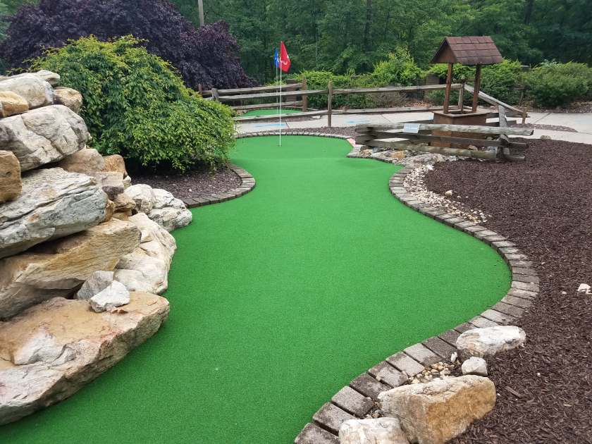 green artificial grass and rocks on miniature golf course